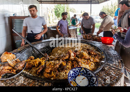 Servir les hommes PLOV (le plat national) à partir d'un grand chaudron au centre de l'Asie centrale plov, Tachkent, Ouzbékistan Banque D'Images