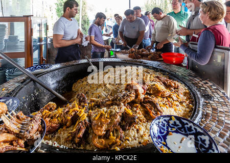 Servir les hommes PLOV (le plat national) à partir d'un grand chaudron au centre de l'Asie centrale plov, Tachkent, Ouzbékistan Banque D'Images