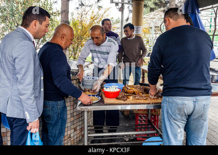 Les hommes cuisiner et servir PLOV (le plat national) à l'Asie centrale Plov Centre, Tachkent, Ouzbékistan Banque D'Images