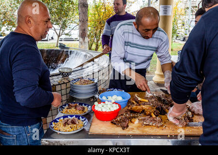 Les hommes cuisiner et servir PLOV (le plat national) à l'Asie centrale Plov Centre, Tachkent, Ouzbékistan Banque D'Images