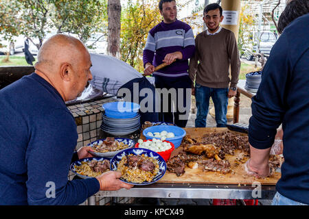 Les hommes cuisiner et servir PLOV (le plat national) à l'Asie centrale Plov Centre, Tachkent, Ouzbékistan Banque D'Images