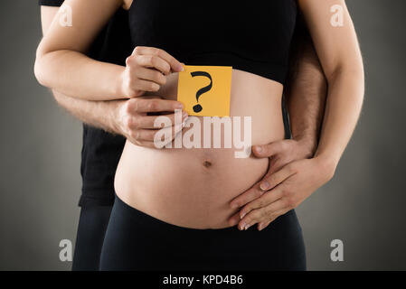 Femme enceinte et l'Homme montrant Question Mark Banque D'Images