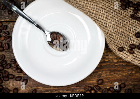 Sur les grains de café avec cuillère plaque blanche et ses environs coffeebeans Banque D'Images