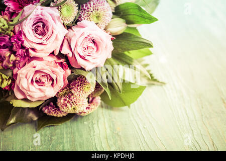 Valentines Day bouquet de belles fleurs roses et rouges dans la moitié supérieure du châssis avec copie espace sur fond vert Banque D'Images