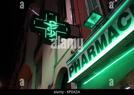 Pharmacie néon vert signe en forme de croix dans la nuit Banque D'Images