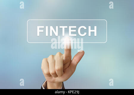 La main d'affaires en cliquant sur le bouton de la technologie financière fintech ou sur l'arrière-plan flou Banque D'Images