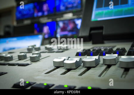 Main sur une table de mixage, lumière dans la télévision fader flou galerie Banque D'Images