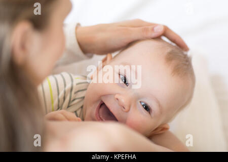 L'allaitement de bébé. Mère tenant son enfant nouveau-né. Petit enfant rire et à la recherche à l'appareil photo. Banque D'Images