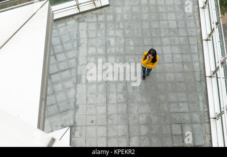 Asian Woman chatting to mobile phone on street Banque D'Images