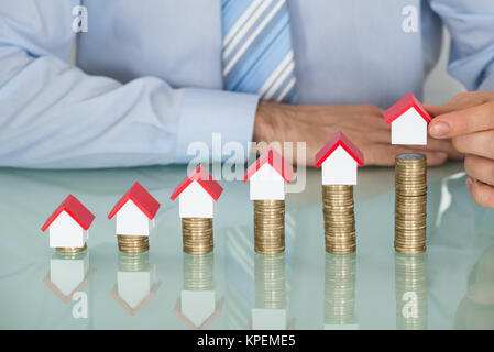 Businessman With House Model sur pièces empilées Banque D'Images