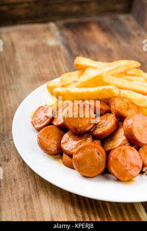 Currywurst avec des frites on a wooden background Banque D'Images