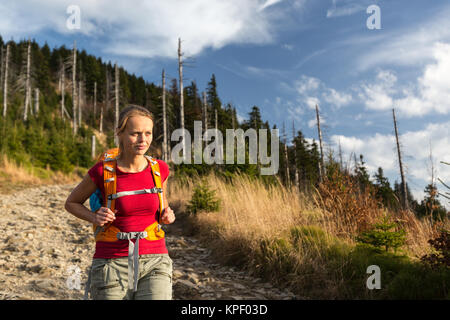 Jolie, female hiker descentes en lumière chaude soirée Banque D'Images