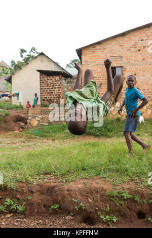 Lugazi, en Ouganda. 18 juin 2017. Un garçon ougandais faisant une bascule dans l'air. Banque D'Images