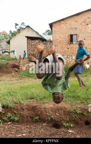 Lugazi, en Ouganda. 18 juin 2017. Un garçon ougandais faisant une bascule dans l'air. Banque D'Images