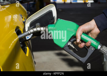 La pompe à gaz mâle main tenant une dernière goutte de carburant fossile Banque D'Images