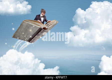 L'homme volant sur un livre sur les nuages Banque D'Images