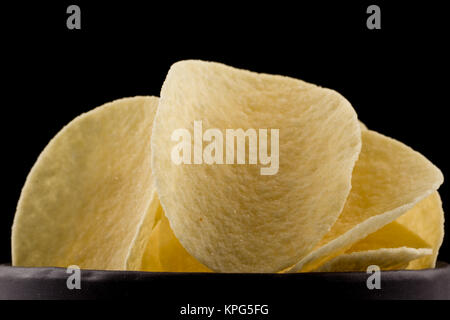 Croustilles de pommes de terre sur un fond noir Banque D'Images