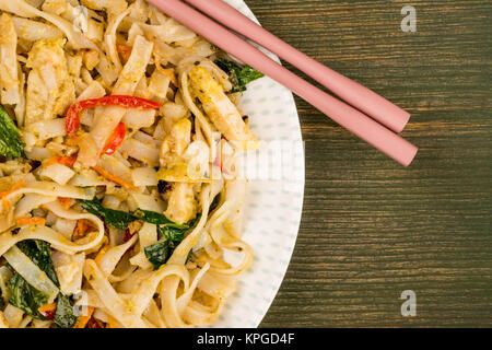 Le style Thai Pad Thaï au poulet avec des nouilles sur un fond de bois vert Banque D'Images