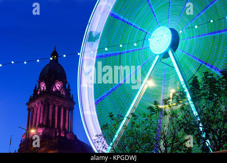 Le trafic passant par les lumières de Noël fête foraine et hôtel de ville de Leeds au crépuscule yorkshire royaume uni Banque D'Images