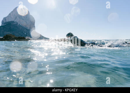 L'homme nage avec sa planche de surf en essayant d'attraper une vague dans la mer méditerranée. Banque D'Images