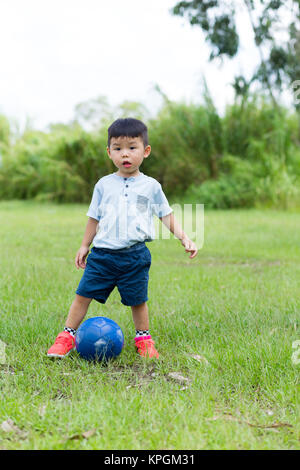 Baby Boy play soccer ball at outdoor Banque D'Images