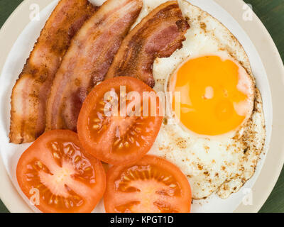 Des oeufs au bacon et tomates nourriture du petit déjeuner sur un fond vert Banque D'Images