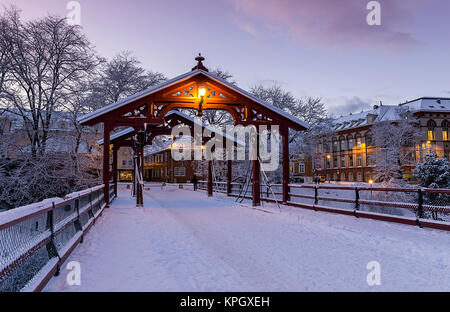 Gamle Bybro est du pont de la vieille ville de Trondheim en Norvège, qui traverse la rivière Nidelva. Ici, il est vu à la tombée de la nuit avec des lumières sur. Banque D'Images