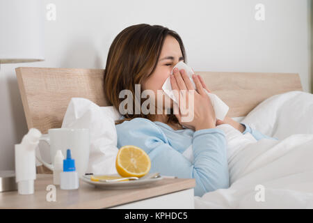 Femme infectée par le froid Lying On Bed Banque D'Images