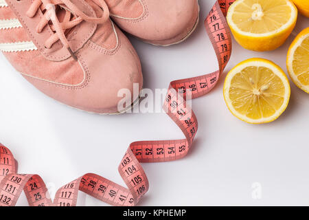 Les vieilles chaussures, un mètre ruban et citron sur un livre blanc Banque D'Images