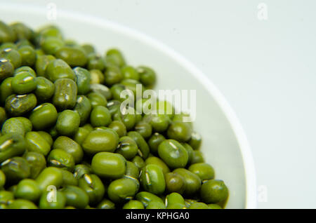 Les haricots mungo dans bol jaune isolé sur fond blanc. Également connu sous le nom de haricots moong, les pois, haricot vert. dans sa famille des légumineuses espèce Banque D'Images