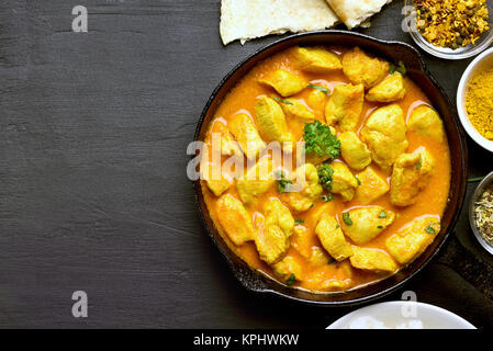 Poulet au curry indien sur fond noir en noir avec l'exemplaire de l'espace. Haut de la vue, télévision lay Banque D'Images