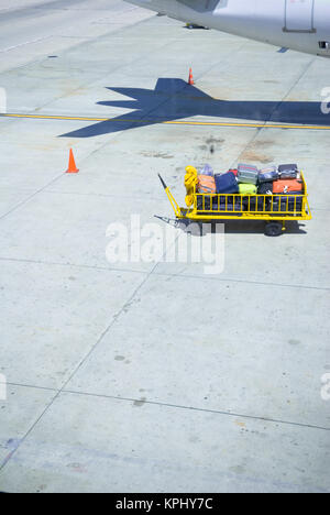 Photo prise depuis l'intérieur de l'avion sur la piste de chargeurs trolley bagages chargés de bagagge Banque D'Images