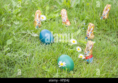 Lapins de chocolat emballées avec des oeufs de Pâques dans l'herbe Banque D'Images