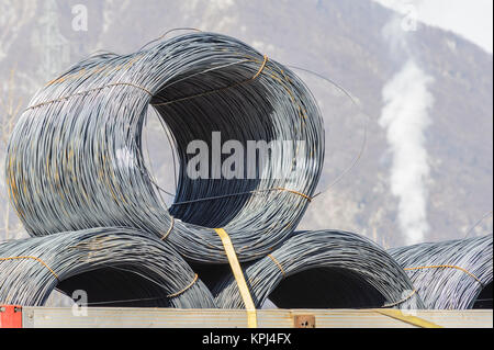 Les rouleaux de fils d'acier. Les rouleaux de fils d'acier de construction industrielle produits sur remorque de transport. Banque D'Images