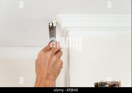 L'installation des moulures au plafond. Met de la colle sur des travailleurs de moulage de plastique pour plus de le fixer au plafond Banque D'Images