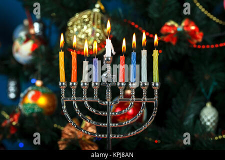 La menorah avec des bougies pour la fête des lumières en arrière-plan de l'arbre du Nouvel An. L'éclairage de Studio Banque D'Images