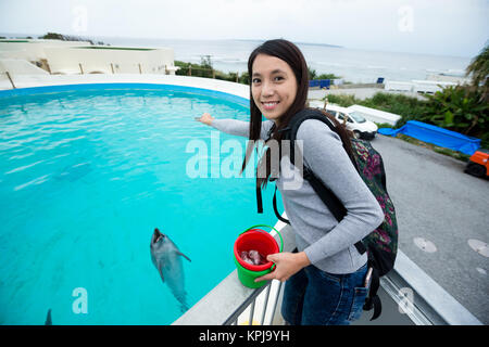 Alimentation femme asiatique dans l'Aquarium des dauphins Banque D'Images