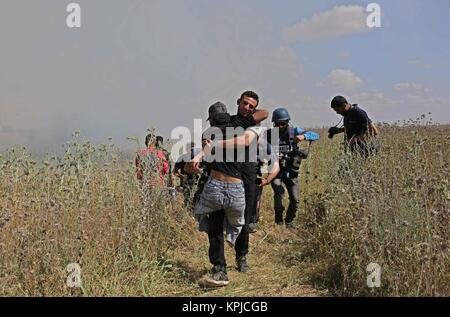 19 mai 2017 - La ville de Gaza, bande de Gaza, territoire palestinien - (fichiers) Ce fichier photo prise le 19 mai 2017 montre un manifestant palestinien porte un camarade handicapé Ibraheem Abu Thuraya, 29 au cours d'affrontements à la suite d'une protestation contre le blocus sur la bande de Gaza, près de Nahal Oz crossing à l'est de la ville de Gaza. Abu Thuraya, qui a été abattu par les forces de sécurité israéliennes au plus tard le vendredi 15 décembre 2017 lors d'affrontements près de la frontière avec Israël à l'est de la ville de Gaza contre le président américain Donald Trump a décidé de reconnaître Jérusalem comme capitale d'Israël (crédit Image : © Ashraf Amra/APA Imag Banque D'Images