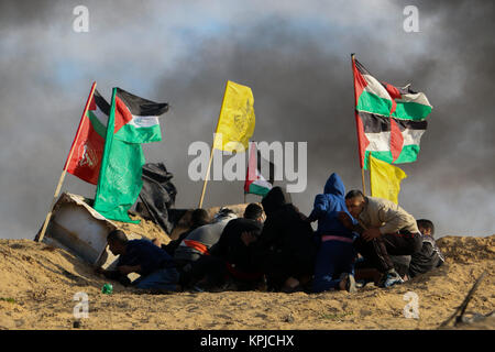 La bande de Gaza. 15 décembre 2017 - Des affrontements éclatent entre manifestants palestiniens et soldats israéliens près de la frontière Gaza-Israel, à l'est de al-Bureij camp de réfugiés palestiniens, à la suite de la prière de midi le vendredi. Les Palestiniens, les manifestants en colère contre la récente nous' reconnaissance de Jérusalem comme capitale d'Israël, ont lancé des pierres sur les forces israéliennes qui ont tiré des gaz lacrymogènes et des balles réelles sur eux. Un certain nombre de manifestants palestiniens ont été blessés dans les affrontements. Credit : ZUMA Press, Inc./Alamy Live News Banque D'Images