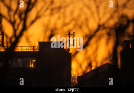 Merton, Londres, Royaume-Uni. 16 Décembre, 2017. Soleil se lève derrière les bâtiments dans le sud ouest de Londres avec frosty clair ciel tôt le matin. Credit : Malcolm Park/Alamy Live News Banque D'Images