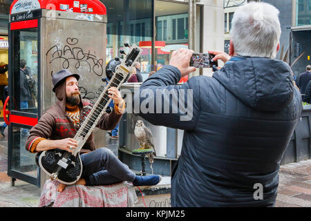 Glasgow, Ecosse, Royaume-Uni. 16 Décembre, 2017. Comme des milliers de visiteurs affluent vers le centre-ville de Glasgow et, en particulier, également connu sous le nom de Buchanan Street Glasgow Style du Mile plusieurs entrées dans l'esprit de saison et avons apprécié le spectacle de la rue, musiciens et amuseurs publics. PAUL JACKSON jouant le sitar accompagné de son animal Crédit : hawk Findlay/Alamy Live News Banque D'Images