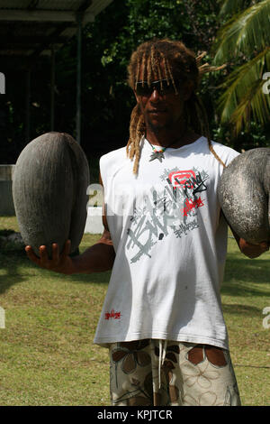 Rasta man holding deux Coco de Mer fruits dans chaque main, l'île Curieuse, Seychelles. Banque D'Images