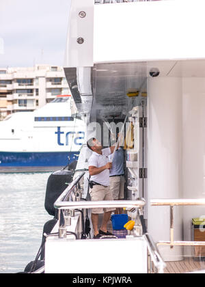 Ibiza, Espagne - le 24 mai 2015. Vue d'un couple de personnes d'un navire de nettoyage dans le port d'Ibiza. Banque D'Images