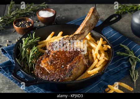 Les steaks cuits Tomahawk nourri à l'herbe avec des frites et de romarin Banque D'Images