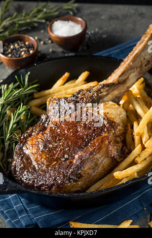 Les steaks cuits Tomahawk nourri à l'herbe avec des frites et de romarin Banque D'Images