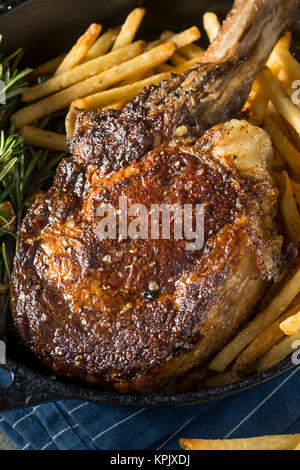 Les steaks cuits Tomahawk nourri à l'herbe avec des frites et de romarin Banque D'Images