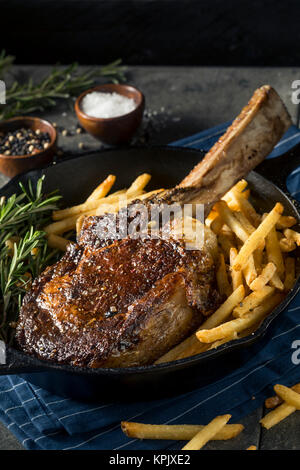 Les steaks cuits Tomahawk nourri à l'herbe avec des frites et de romarin Banque D'Images