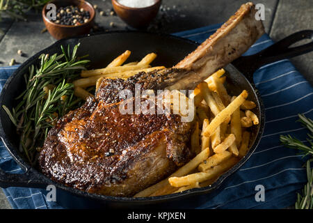 Les steaks cuits Tomahawk nourri à l'herbe avec des frites et de romarin Banque D'Images