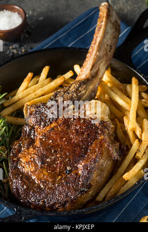 Les steaks cuits Tomahawk nourri à l'herbe avec des frites et de romarin Banque D'Images