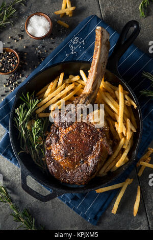 Les steaks cuits Tomahawk nourri à l'herbe avec des frites et de romarin Banque D'Images